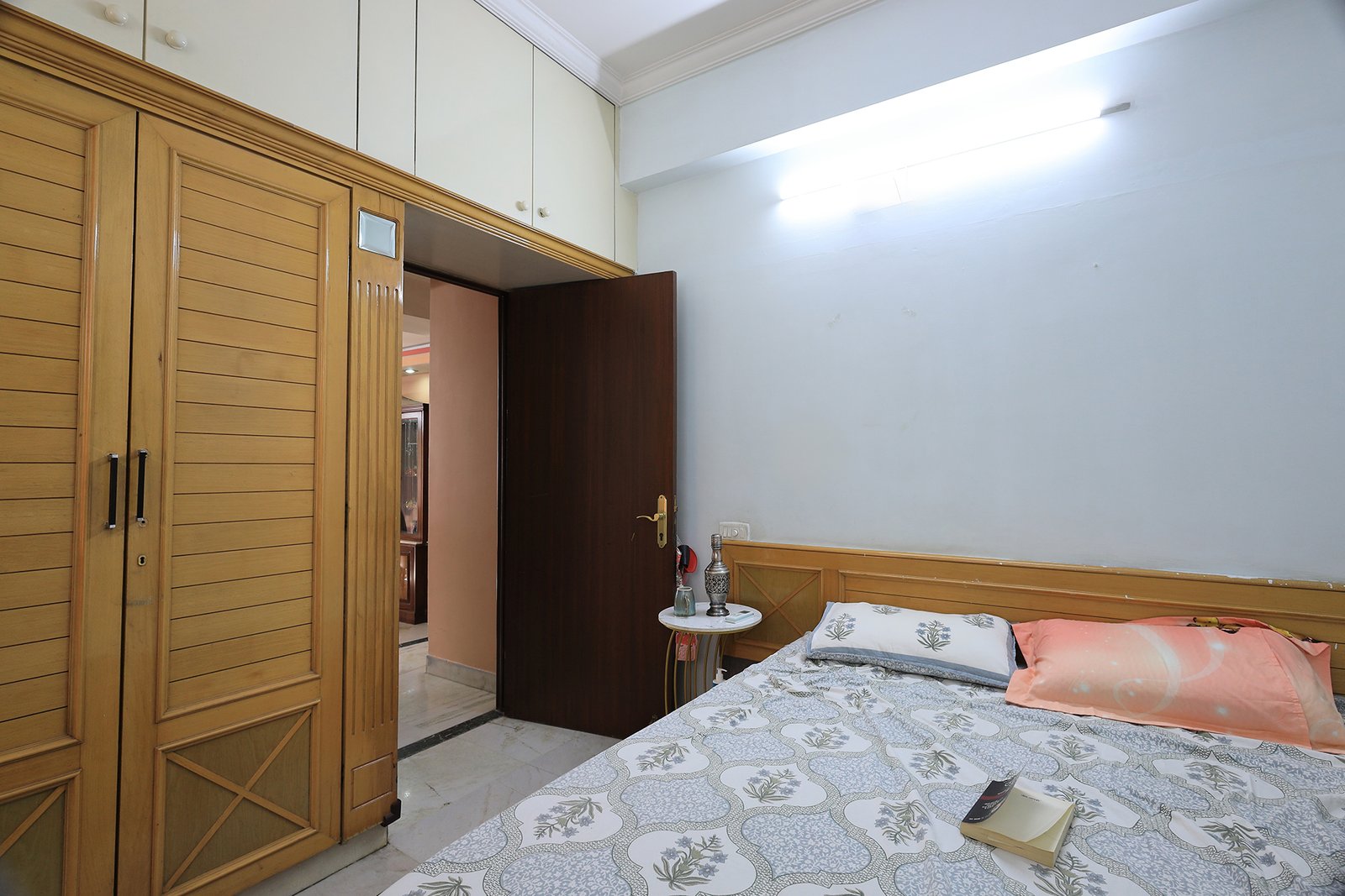 Bedroom 3 with wooden wardrobe, overhead cabins, and door through to the rest of the home